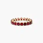 A Milgrain Embellished Ruby Eternity Ruby Wedding Rings For Women band (3.00mm) in 14K Yellow Gold with 2.25 CTW Round Rubies and diamond accents.