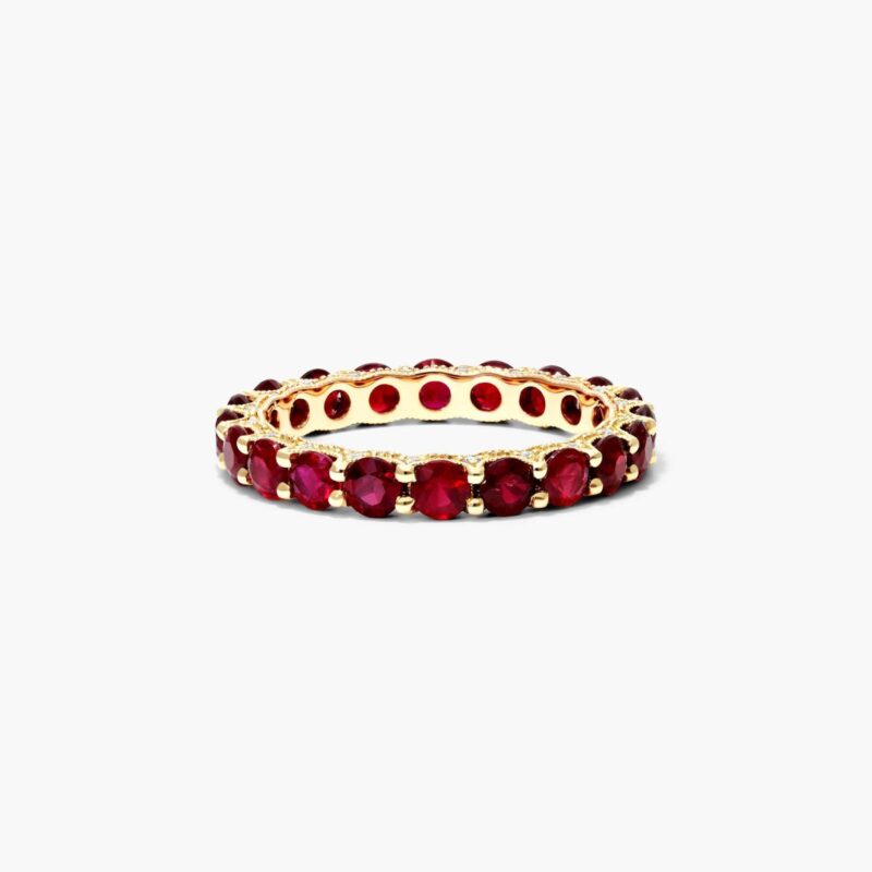 A Milgrain Embellished Ruby Eternity Ruby Wedding Rings For Women band (3.00mm) in 14K Yellow Gold with 2.25 CTW Round Rubies and diamond accents.