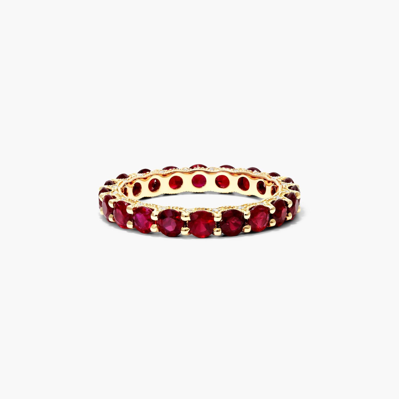 A Milgrain Embellished Ruby Eternity Ruby Wedding Rings For Women band (3.00mm) in 14K Yellow Gold with 2.25 CTW Round Rubies and diamond accents.