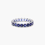 A 14K White Gold Blue Sapphire and Diamond Wedding Ring Sets component: a 3.00 mm Milgrain Embellished Eternity Band with 2.25 Carat minimum Round Blue Sapphires and 0.11 CTW diamond accents.