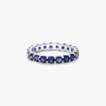 A 14K White Gold Blue Sapphire and Diamond Wedding Ring Sets component: a 3.00 mm Milgrain Embellished Eternity Band with 2.25 Carat minimum Round Blue Sapphires and 0.11 CTW diamond accents.