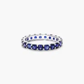 A 14K White Gold Blue Sapphire and Diamond Wedding Ring Sets component: a 3.00 mm Milgrain Embellished Eternity Band with 2.25 Carat minimum Round Blue Sapphires and 0.11 CTW diamond accents.