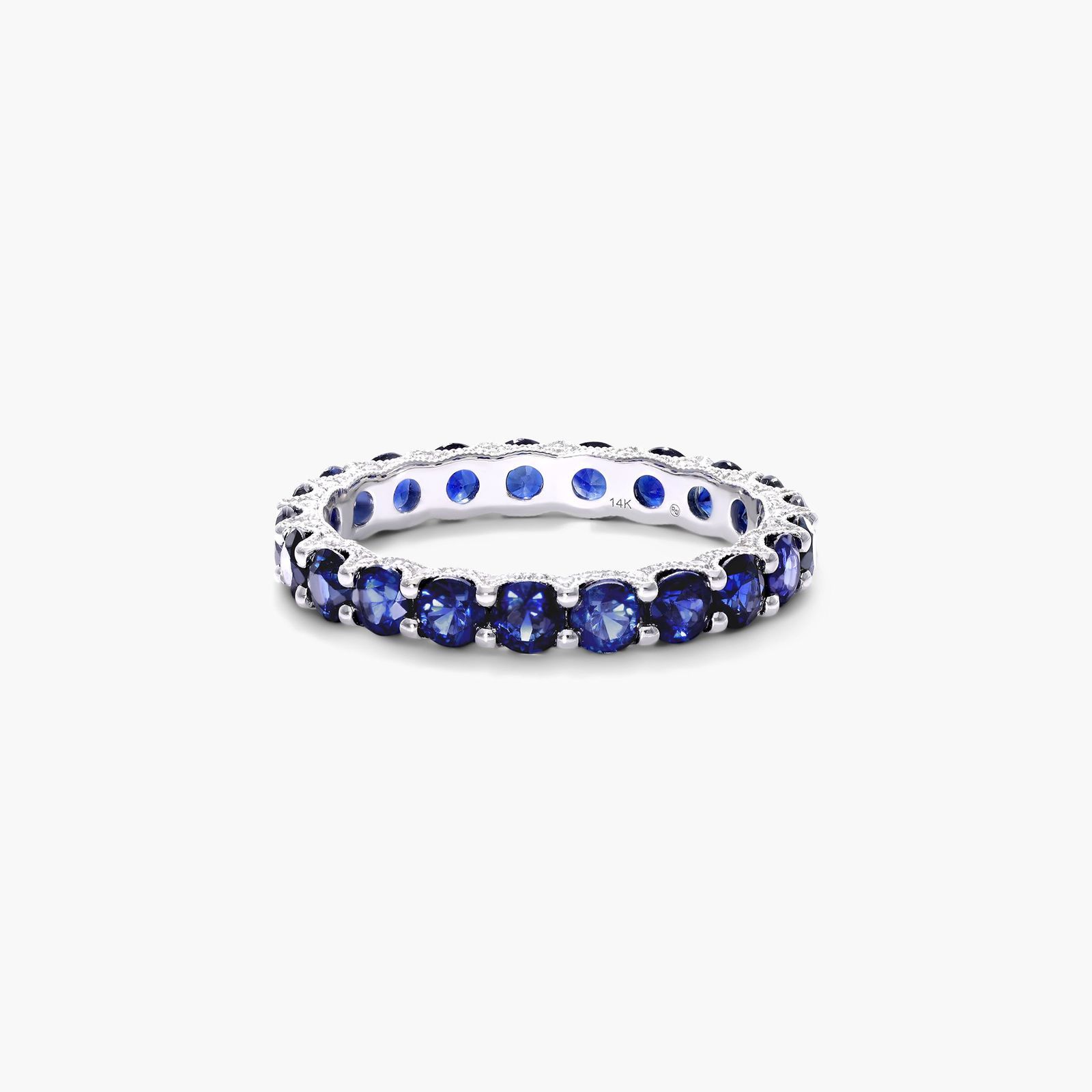 A 14K White Gold Blue Sapphire and Diamond Wedding Ring Sets component: a 3.00 mm Milgrain Embellished Eternity Band with 2.25 Carat minimum Round Blue Sapphires and 0.11 CTW diamond accents.
