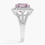 An 18K White Gold Pink Sapphire and Diamond Ring, designed as a Cocktail Ring, featuring a 5.04 Carat Oval Pink Sapphire center stone surrounded by a halo of Round and Baguette diamonds (0.94 CTW total).