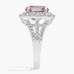 An 18K White Gold Pink Sapphire and Diamond Ring, designed as a Cocktail Ring, featuring a 5.04 Carat Oval Pink Sapphire center stone surrounded by a halo of Round and Baguette diamonds (0.94 CTW total).