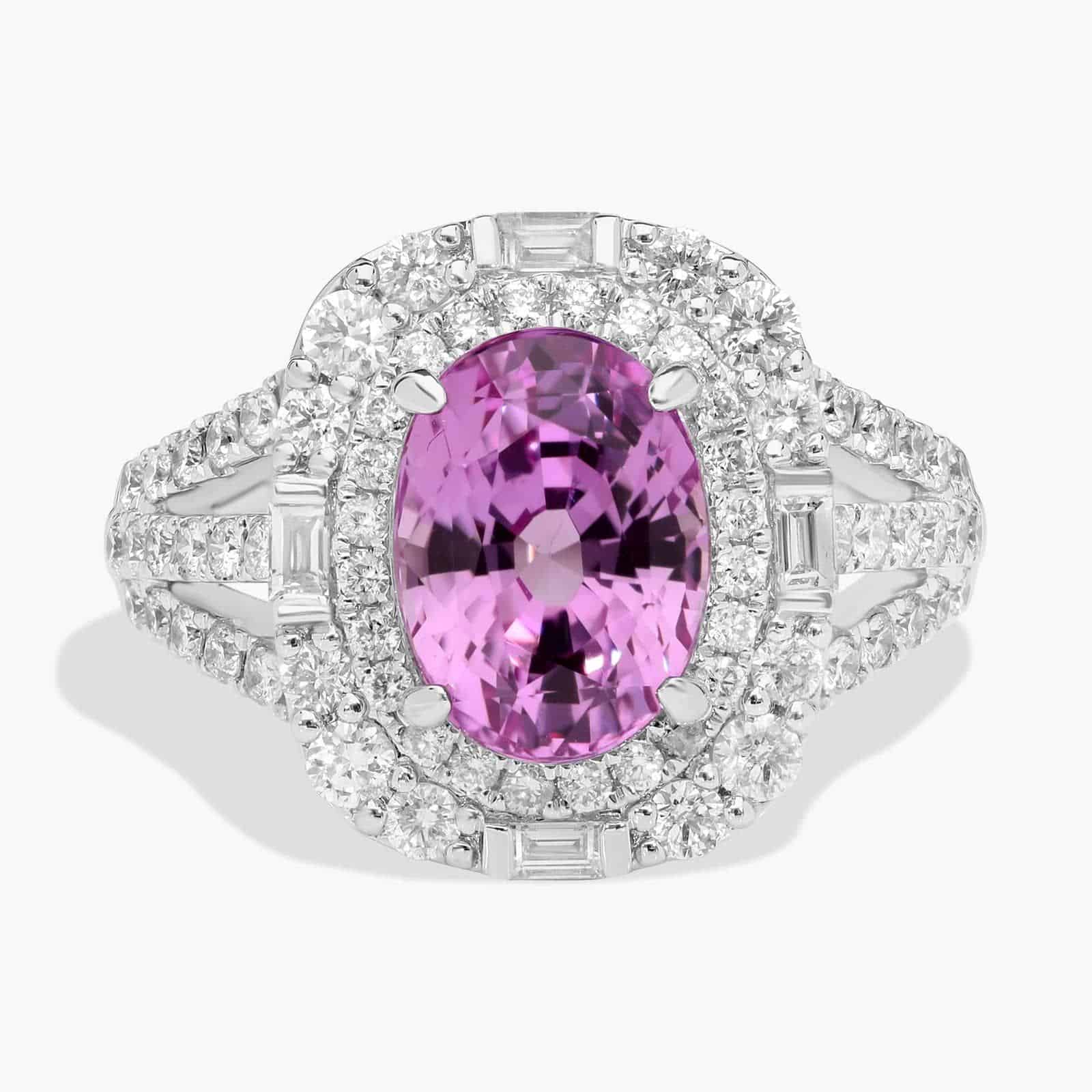 oval-halo-pink-sapphire-diamond-ring-18k-5-04ct An 18K White Gold Pink Sapphire and Diamond Ring, designed as a Cocktail Ring, featuring a 5.04 Carat Oval Pink Sapphire center stone surrounded by a halo of Round and Baguette diamonds (0.94 CTW total).