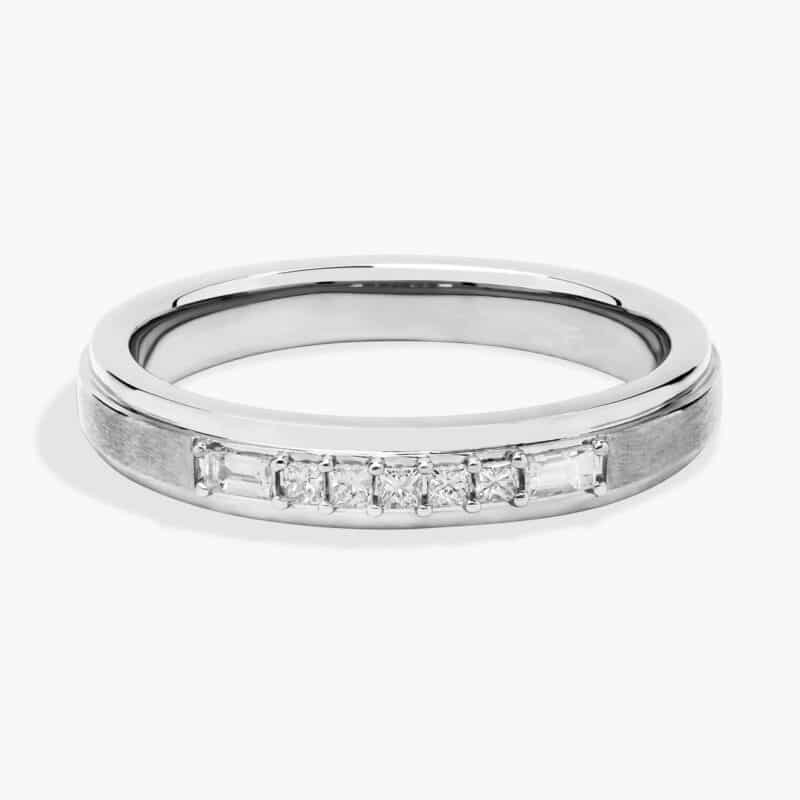 A 3.60 mm wide Platinum Mens Wedding Bands With Baguettes featuring an alternating pattern of Baguette and Princess Cut natural diamonds (1/5 CTW).