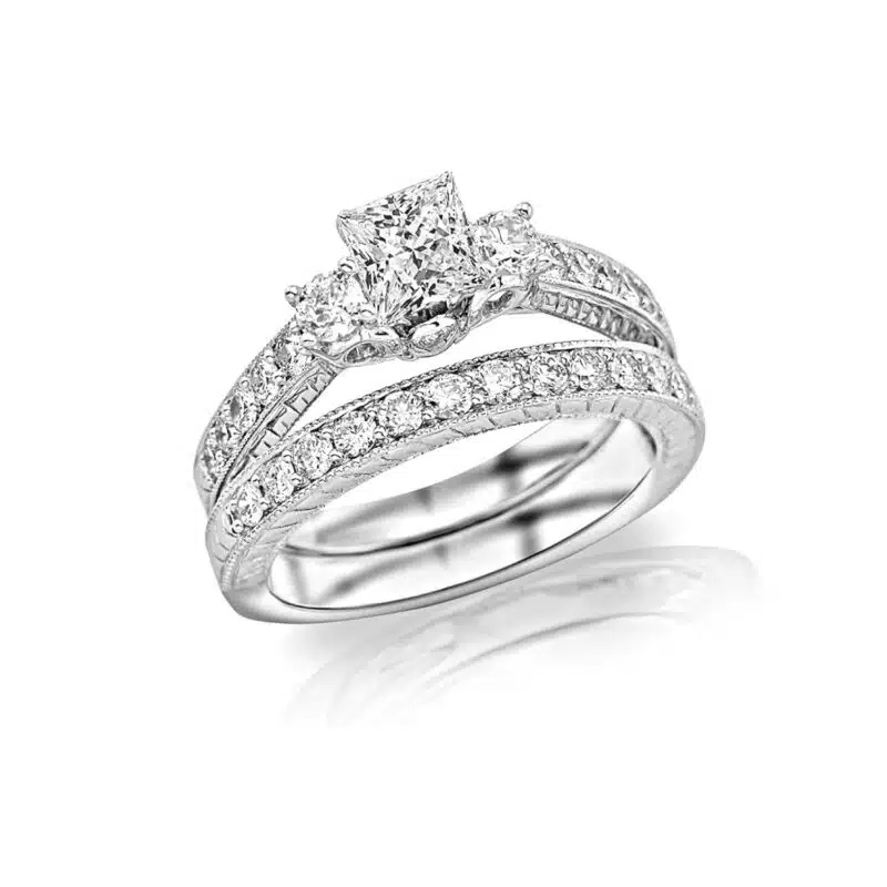 A White Gold 3 Stone Princess Cut Engagement Ring With Wedding Band set, featuring vintage Milgrain and Filigree detailing and 1.48 Carat Total Weight of Princess Cut diamonds.