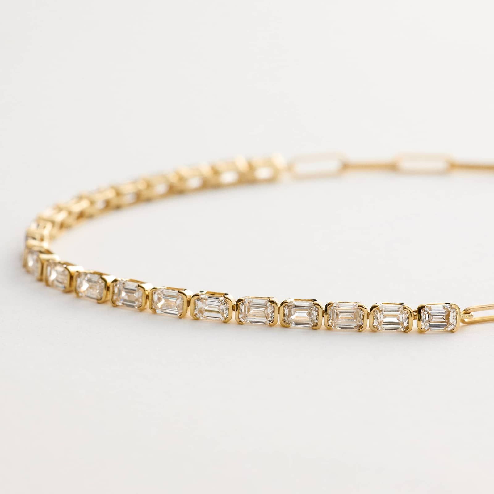14K yellow gold emerald cut lab grown diamond tennis bracelets under $3000 featuring 2 CTW bezel-set diamonds and a paperclip chain.