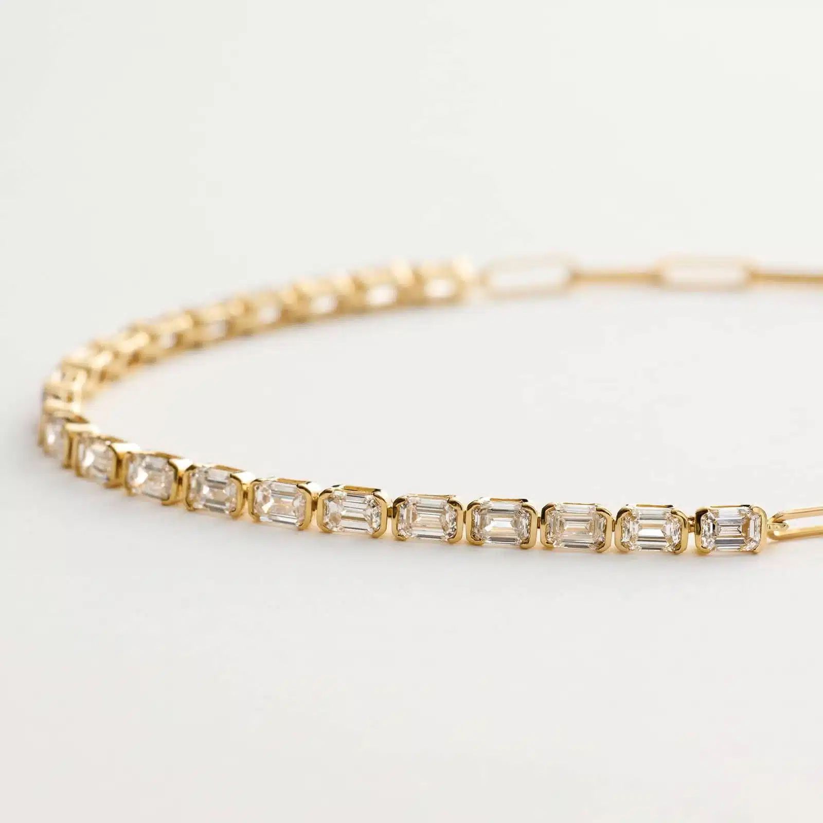14K yellow gold emerald cut lab grown diamond tennis bracelets under $3000 featuring 2 CTW bezel-set diamonds and a paperclip chain.