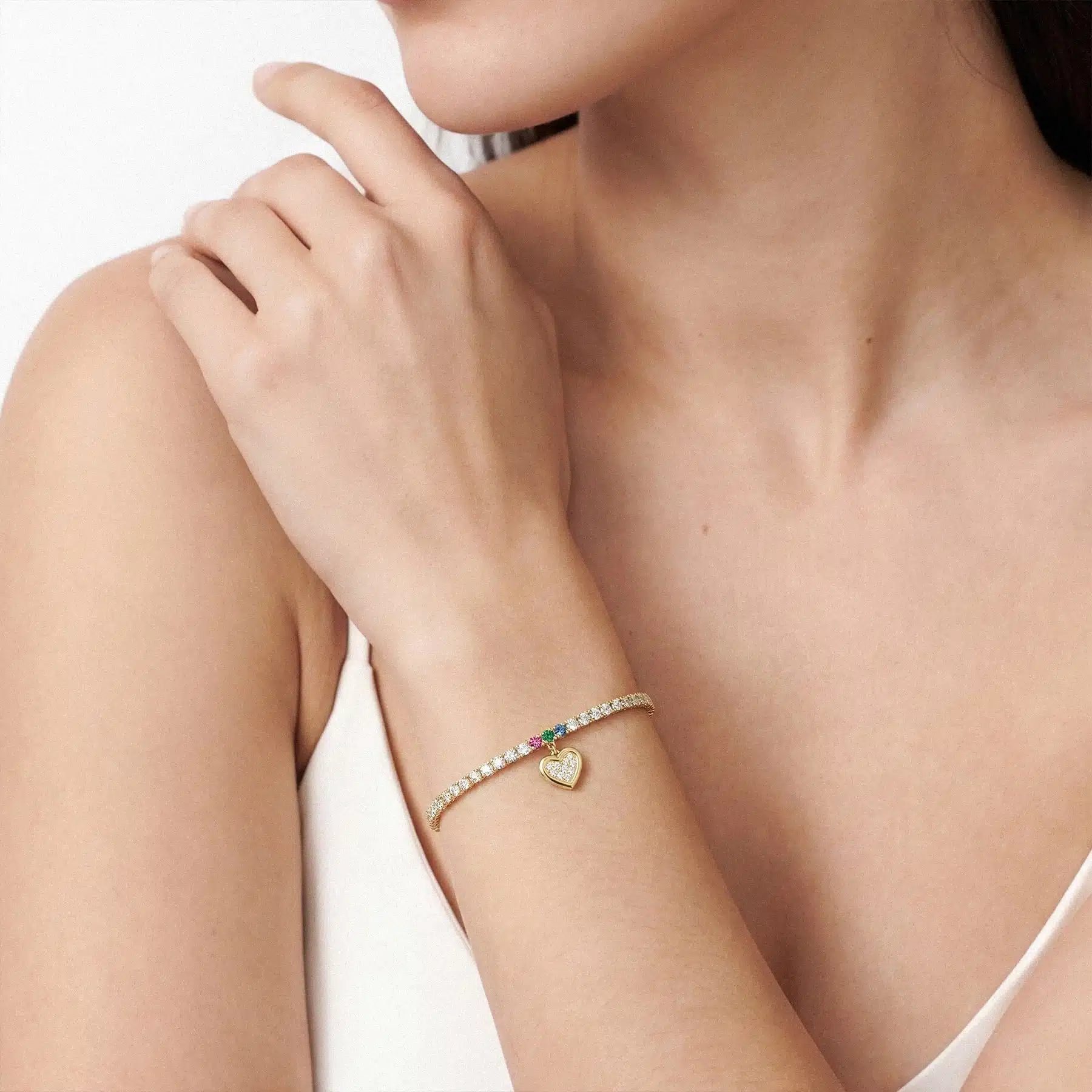 14K yellow gold lab grown diamond tennis bracelets under $3000 featuring a pavé heart charm and a ruby, emerald, and sapphire set clasp.