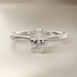 Platinum oval solitaire engagement rings under $2,500 featuring a 1.5 carat oval lab-grown diamond on a 1.80mm petite band.