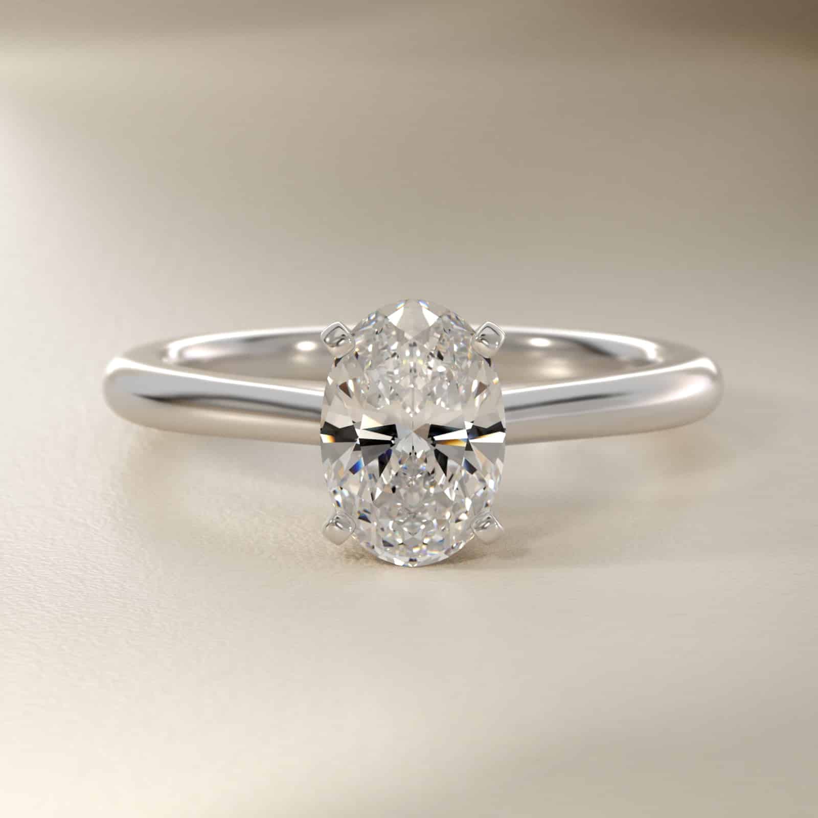 Platinum oval solitaire engagement rings under $2,500 featuring a 1.5 carat oval lab-grown diamond on a 1.80mm petite band.
