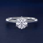 Platinum six prong solitaire engagement rings under $2,500 featuring a 1.5 carat round colorless lab grown diamond on a petite 1.80mm Nouveau band.