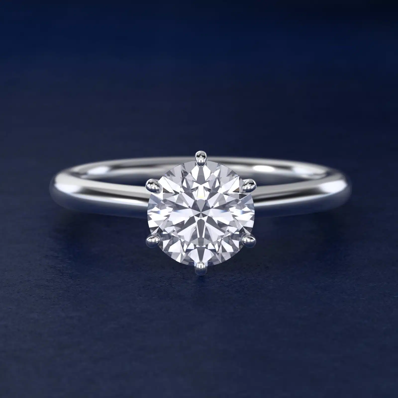 Platinum six prong solitaire engagement rings under $2,500 featuring a 1.5 carat round colorless lab grown diamond on a petite 1.80mm Nouveau band.